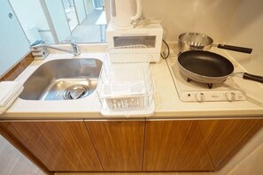 A kitchen with a sink, a stove, and a frying pan. - Shinsaibashi H2H 901 (Osaka)