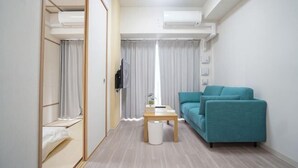 A modern room with a sofa, a small table, a wardrobe, and an air conditioning unit. - Shinsaibashi H2H 901 (Osaka)