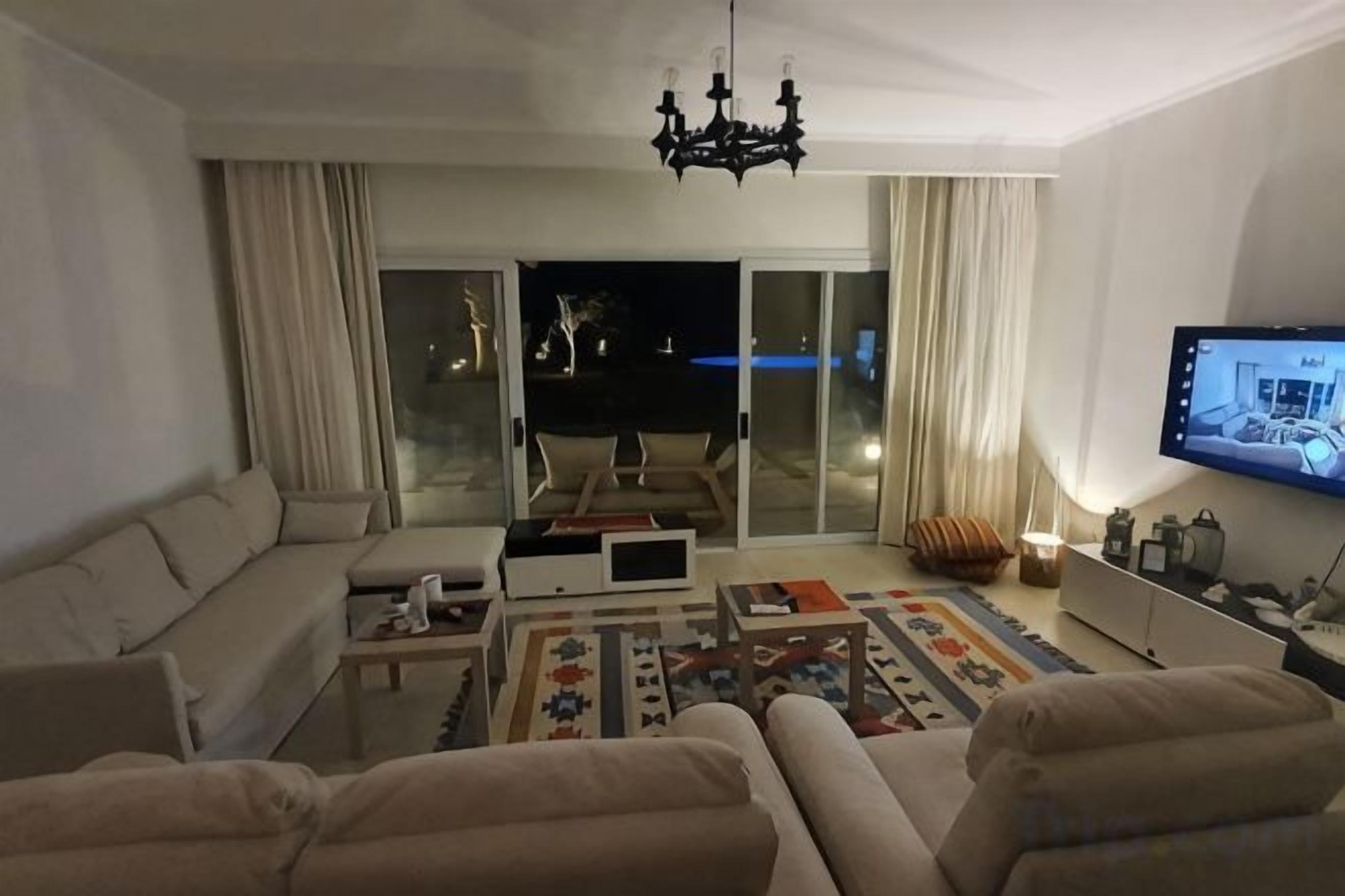 Una sala de estar con un sofá, una mesa de centro y un televisor.