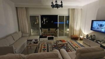 Una sala de estar con un sofá, una mesa de centro y un televisor.