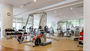 A gym with weightlifting equipment, mirrors, and a wooden floor. - Central 2BR Apt 5 mins to KLCC Twin Towers (Kuala Lumpur)