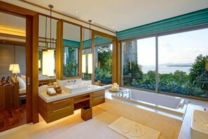 A modern bathroom with dual sinks, a large mirror, and a view of the sea. - The Sawan (Phuket)