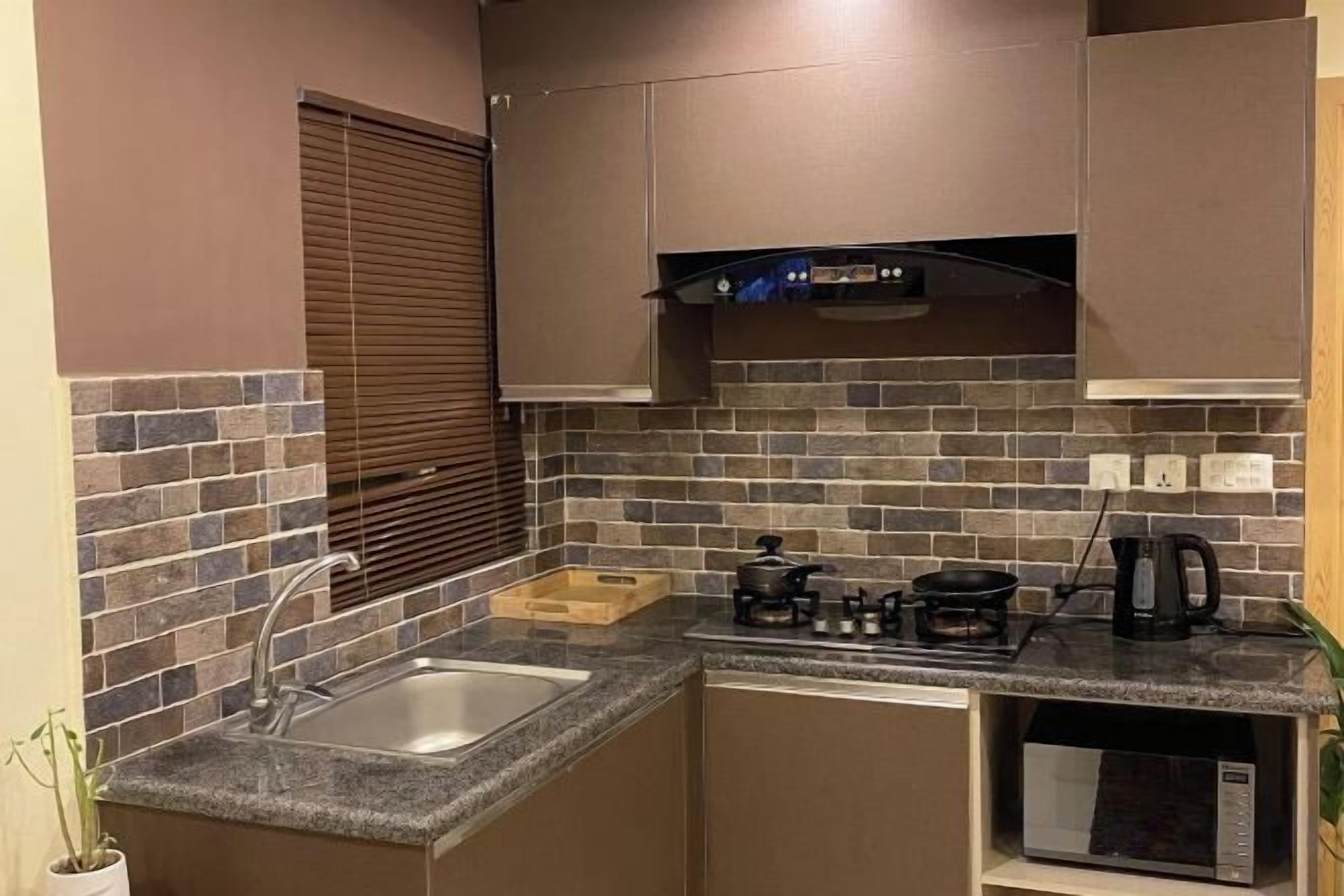 A compact kitchen with a gas stove, microwave, and a sink.