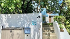A gated entrance with a mailbox, a sign reading "BLUE OCEAN," and a staircase leading to a building. - Blue Ocean Izu (Atami)