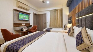 Una habitación de hotel con una cama, un escritorio, un televisor y un ventilador de techo.