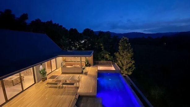 A modern house with a swimming pool, wooden deck, and glass walls. - KIN Pool Villa Khaoyai (Pak Chong)