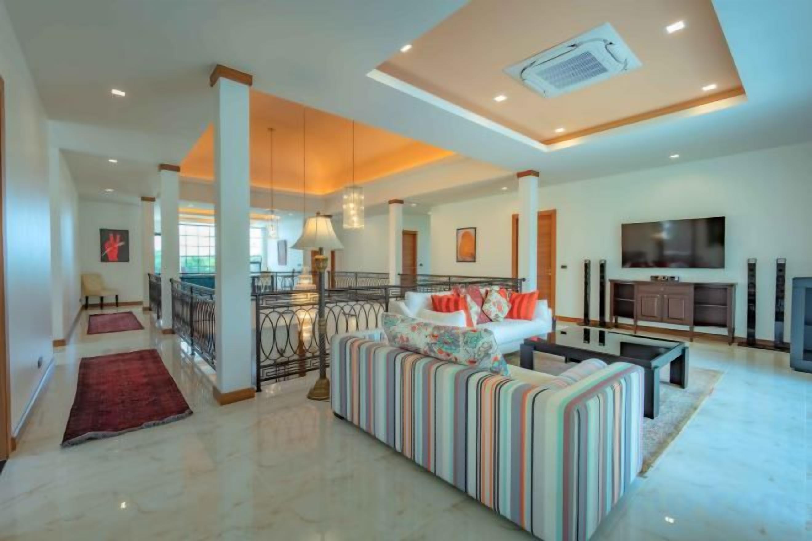 A spacious living area with a sofa, a television, and a balcony.
