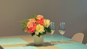 A table with a vase of flowers and two wine glasses. - GreenNarae Stay Sadang (Seoul)
