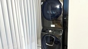 A stacked washer and dryer unit with a control panel and a vent. - GreenNarae Stay Sadang (Seoul)