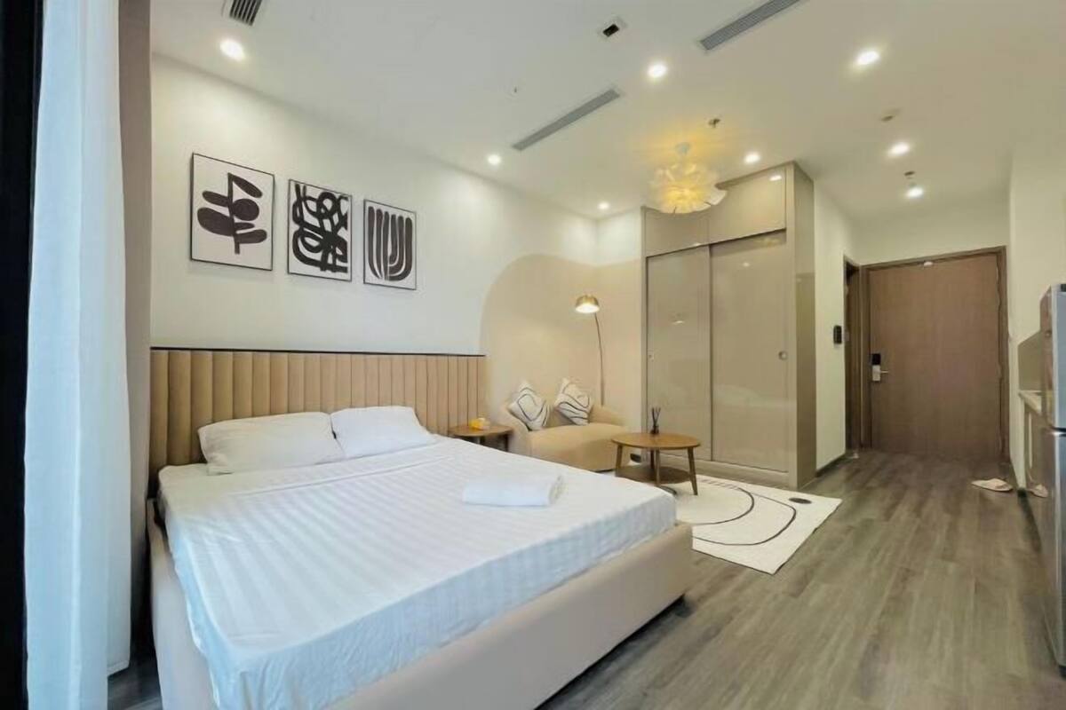 Une chambre d’hôtel moderne équipée d’un grand lit, d’un canapé, d’un bureau et d’une armoire.