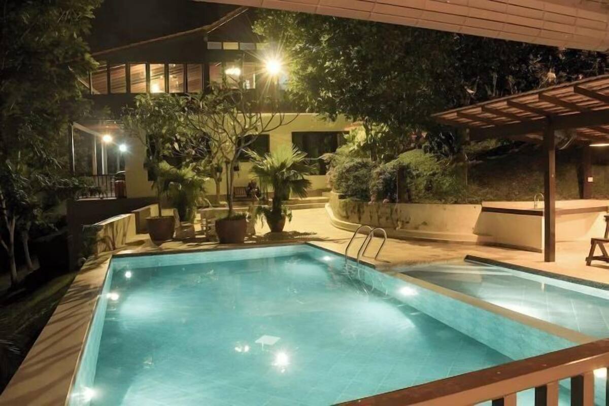 Una piscina con cubierta de madera y plantas en macetas.