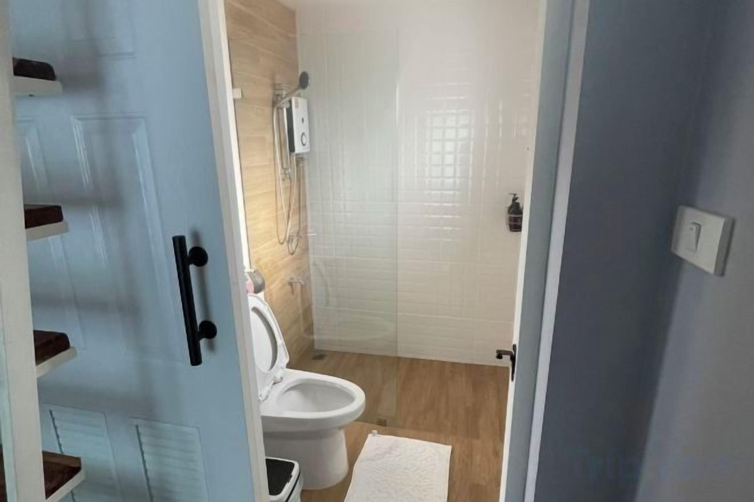A bathroom with a toilet, a shower, and a sink.