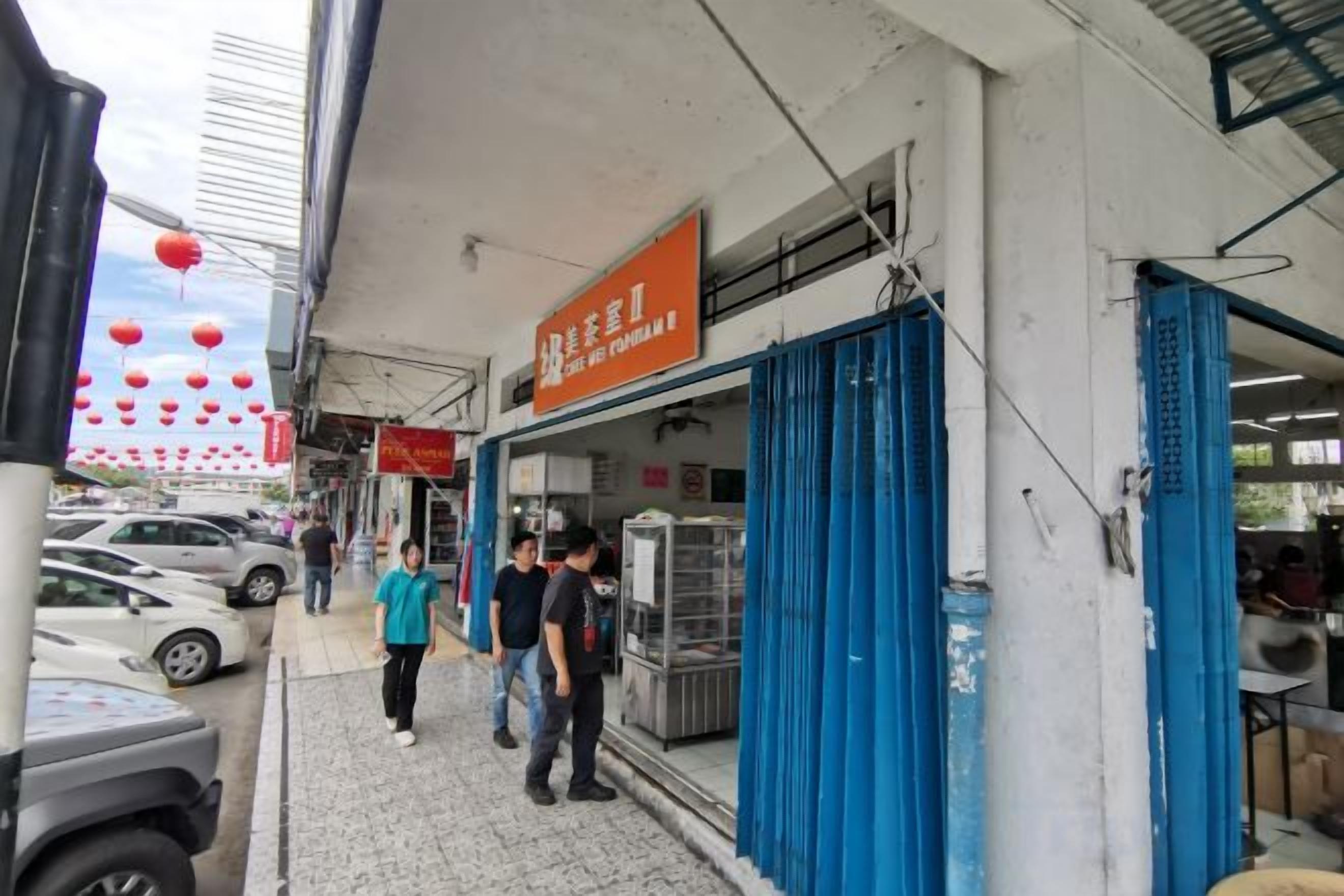 A street scene with a building featuring a blue door and a signboard.
