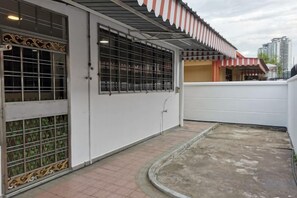 Ein Gebäude mit einem befestigten Eingang, einem überdachten Außenbereich und einem sichtbaren Balkon.