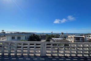 A coastal residential area with buildings and a clear sky. - Nukanuka ぬかぬか (Miyakojima)