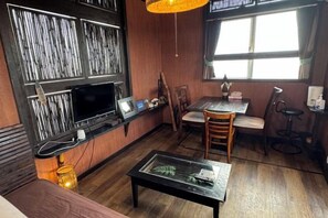 A room with a television, a small table, a sofa, and a window with curtains. - Nukanuka ぬかぬか (Miyakojima)