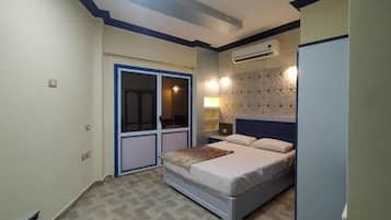 A bedroom with a bed, a wardrobe, a nightstand, and an air conditioning unit.