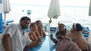 Eine Gruppe von Menschen sitzt an einem Tisch mit Blick auf das Meer.