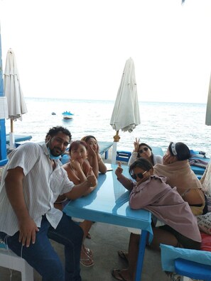 Un grupo de personas sentadas a una mesa con vista al mar.