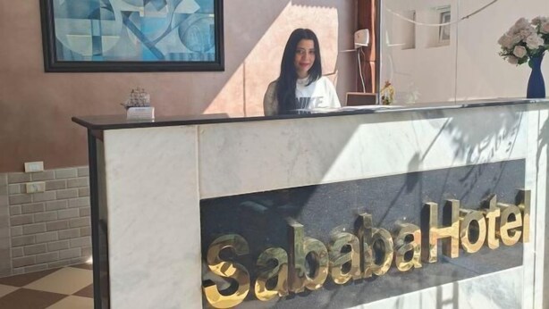 Una reception con un cartello che recita 'Sababa Hotel'.
