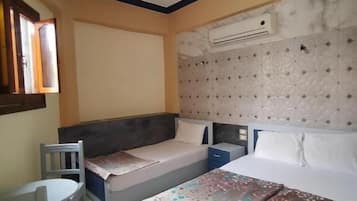 Quarto com duas camas, uma mesinha e uma cadeira.