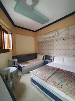 Un dormitorio con dos camas, una mesita y una silla.