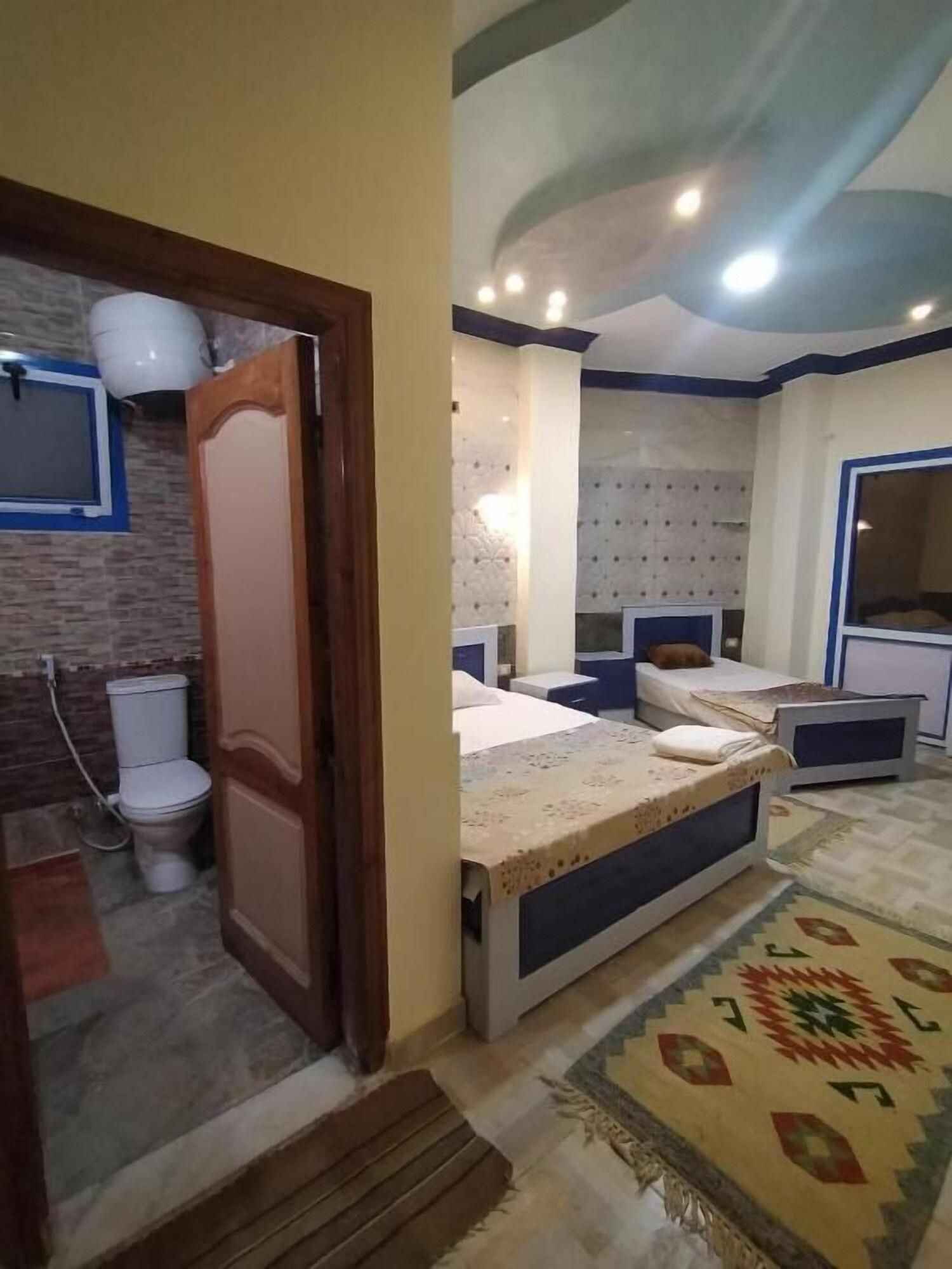 A bedroom with a bed, bedside tables, a mirror, and a patterned rug.