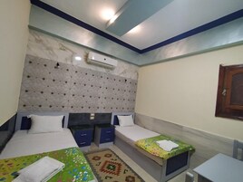 Una habitación de hotel con dos camas, una mesita pequeña y una silla.