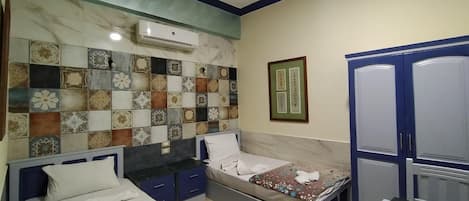 Un dormitorio con dos camas, un armario, una pared con azulejos y un equipo de aire acondicionado.