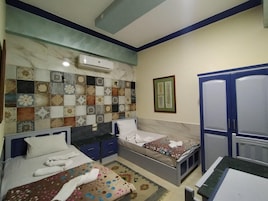 Un dormitorio con dos camas, un armario, una pared con azulejos y un equipo de aire acondicionado.