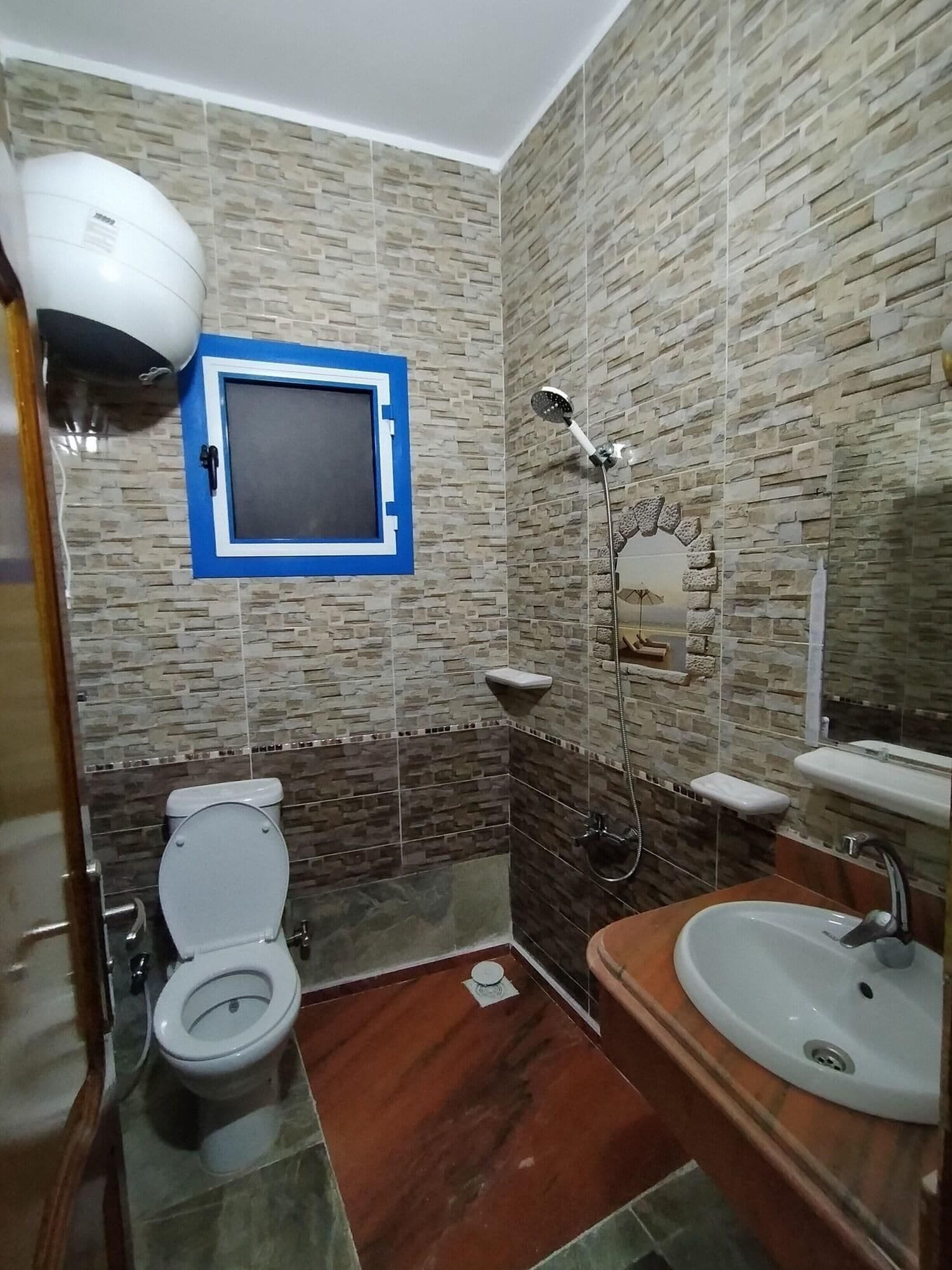 Un baño con inodoro, lavamanos, ducha y espejo.