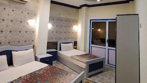 Ein Schlafzimmer mit Bett, Nachttischen, einem Kleiderschrank und einer Decke mit Einbauleuchten.