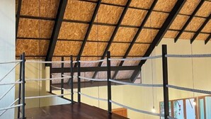 A wooden ceiling with a grid pattern, a wooden floor, and a rope barrier. - "Peace in Ranong: Your Cozy Retreat" (Kapoe)