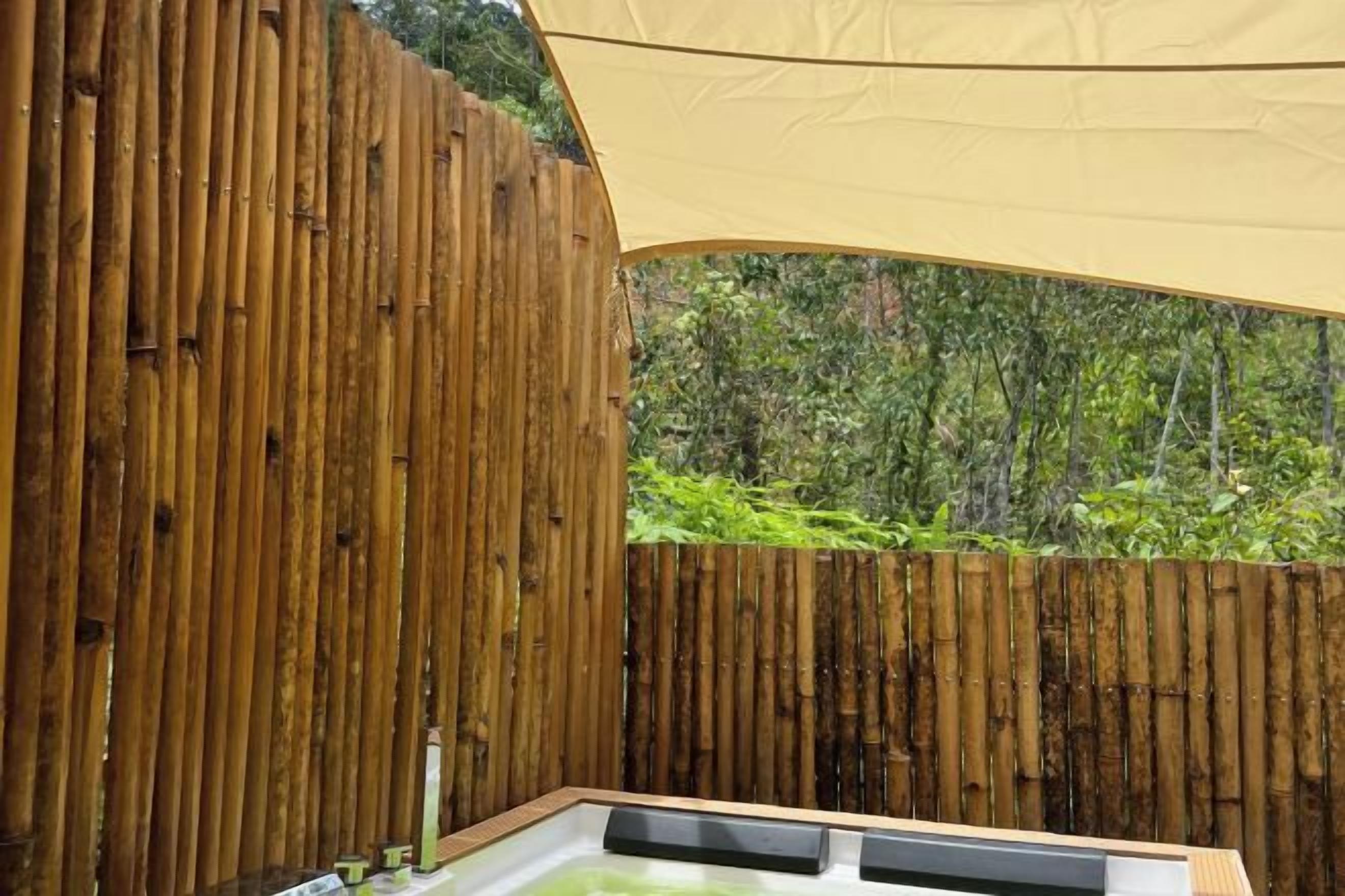 Una cerca de madera, un espacio al aire libre cubierto y vistas al verdor.