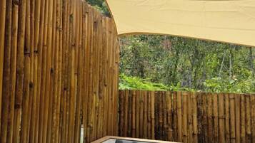 Una cerca de madera, un espacio al aire libre cubierto y vistas al verdor.