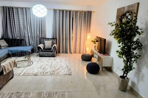 Una sala de estar moderna con un sofá, un sillón y una planta en maceta.