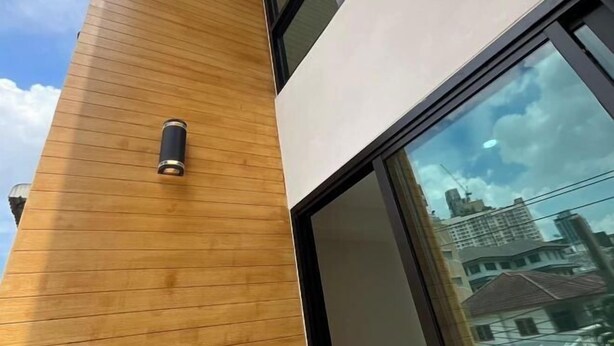 A modern building with a wooden facade and large windows. - Stylish Modern Home 4Bedroom 7Bed 200m BTS PhraKhanong, 10min ThongLo (Bangkok)