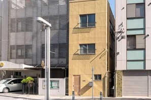 A modern building with a parking garage, a covered entrance, and a streetlight. - Triphome Kinshicho (Tokyo)