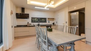 Une cuisine moderne équipée d’une table à manger, de chaises et d’un four encastré.