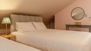 Une chambre à coucher avec un grand lit, une table de chevet avec une lampe, une commode et un miroir au mur.