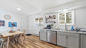 A modern kitchen with a wooden dining table, built-in appliances, and a window with a view. - Remodeled PET Friendly Unit | Near Downtown Palmer (Palmer)