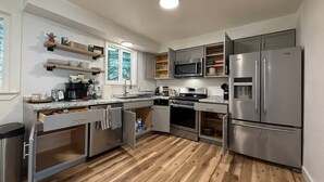 A modern kitchen with built-in appliances, wooden flooring, and a window providing natural light. - Remodeled PET Friendly Unit | Near Downtown Palmer (Palmer)
