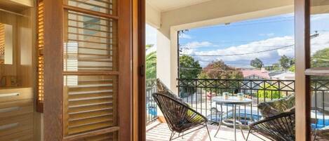Ein Balkon mit Billardtisch, zwei Stühlen und Blick auf die Umgebung.