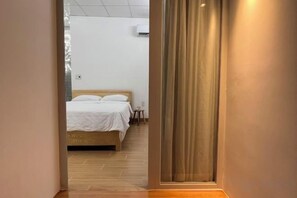 A hotel room with a bed, a small table, and a curtain. - Central, Near Airport, Dragon Bridge - Gau's House (Da Nang)