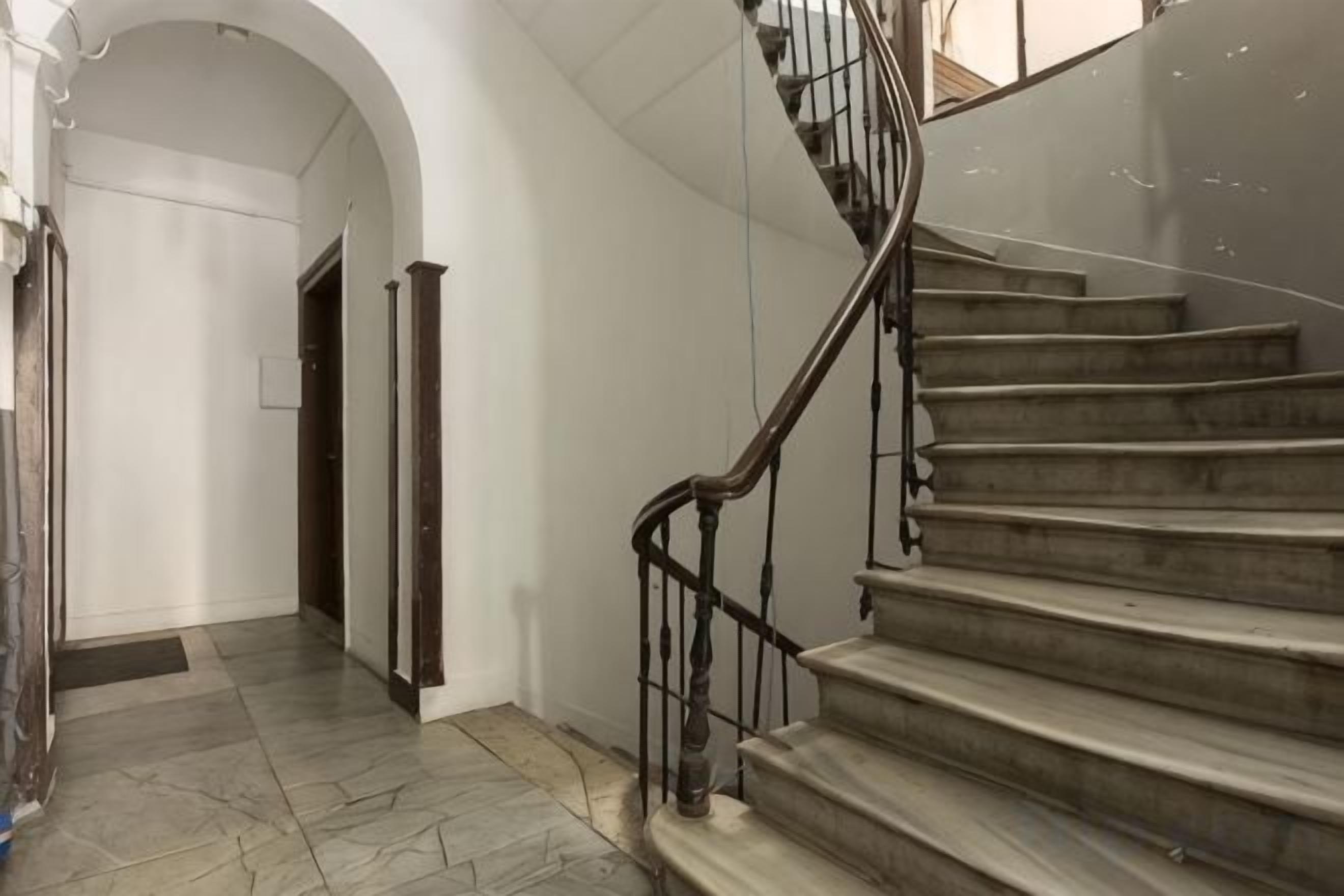 A staircase with a metal handrail leading to an upper floor.