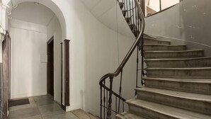 A staircase with a handrail, a landing, and a door at the top. - Ganbaru Tours - Flats in Galata (Istanbul)