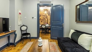 A living room with a TV, a sofa, a wooden coffee table, and a chair. - Ganbaru Tours - Flats in Galata (Istanbul)