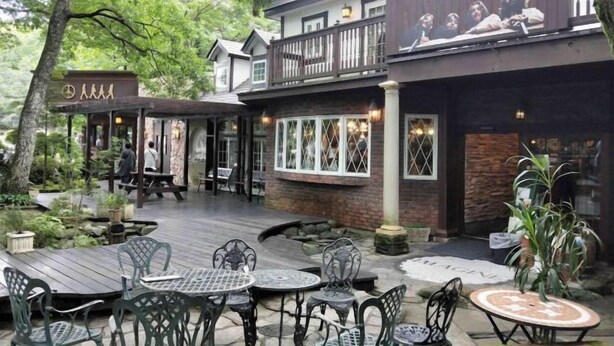 A restaurant with outdoor seating, a wooden deck, and a stone pathway. - Cottage morikaze terrace (Nasu)