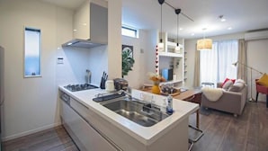 Een moderne keuken met een centraal eiland, een ingebouwde oven en een roestvrijstalen spoelbak.