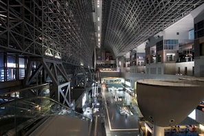 Un intérieur moderne avec un plafond haut, des rampes en verre et une grande structure centrale.